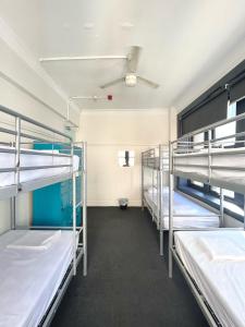 a room with several bunk beds in it at The Downing Hostel in Sydney