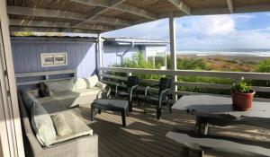 porche con sofá, sillas y mesa en Casa Pichilemu, en Pichilemu