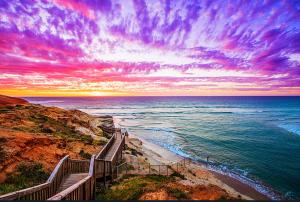 a stairway leading down to the ocean at sunset at Hallett Cove House 6Bed 3Bath Full Kitchen Fast Wifi 5TV Netflix Espresso-Perfect for large families in Halletts Cove