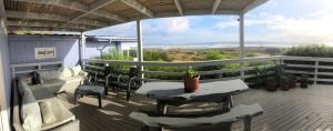 Un patio con mesas y sillas en un balcón. en Casa Pichilemu, en Pichilemu