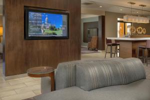 salon z kanapą i telewizorem na ścianie w obiekcie Courtyard by Marriott New Haven Orange w mieście Orange