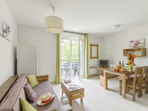 uma sala de estar com um sofá e uma mesa em Nice apartment with a dishwasher near a recreational lake em Aureilhan