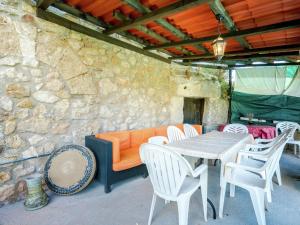 a patio with a table and chairs and a stone wall at Mansion in Salinillas de Buradón with pool in Salinillas de Buradón