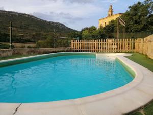 a swimming pool in a yard with a wooden fence at Mansion in Salinillas de Buradón with pool in Salinillas de Buradón