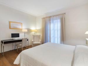 1 dormitorio con 1 cama y escritorio con ordenador en Modern Holiday Home in Rignano sull'Arno with Swimming Pool, en Rignano sullʼArno