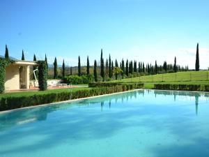 una gran piscina de agua azul con árboles en el fondo en Modern Holiday Home in Rignano sull'Arno with Swimming Pool, en Rignano sullʼArno