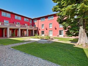 ein großes rotes Gebäude mit einem Baum davor in der Unterkunft Modern Holiday Home in Rignano sull'Arno with Swimming Pool in Rignano sullʼArno