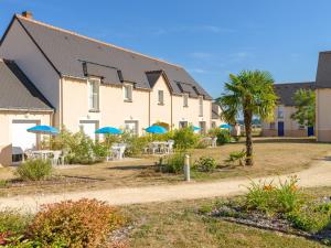 uma fila de casas com mesas e guarda-chuvas azuis em Holiday Home with garden and terrace em Azay-le-Rideau