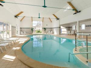 uma grande piscina numa grande sala com mesas e cadeiras em Holiday Home with garden and terrace em Azay-le-Rideau