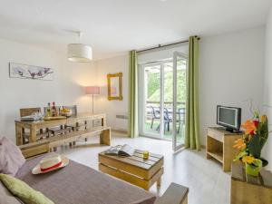 een woonkamer met een bank en een tv bij Nice apartment with a dishwasher near a recreational lake in Aureilhan