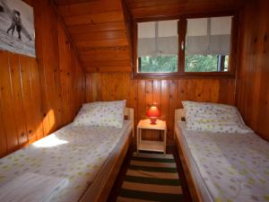 two beds in a room with a lamp on a table at Restful Holiday Home in Vrbovsko with Garden and Barbecue in Vrbovsko
