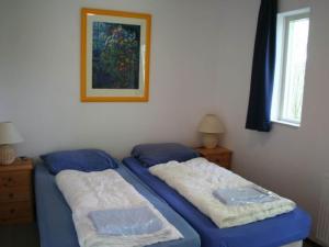2 camas en un dormitorio con una foto en la pared en Chalet in Texel by the Dunes & Water, en De Cocksdorp 32 fotos más
