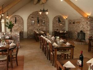 a dining room with tables and chairs and brick walls at Villa in Texel near De Krim Holiday Park in De Cocksdorp
