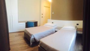 a hotel room with two beds and a desk at Locanda Ai Due Orsi in Milan