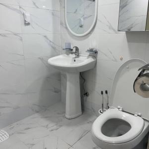 a white bathroom with a toilet and a sink at Our secret movie theater, Netflix, popcorn, free parking in Seoul