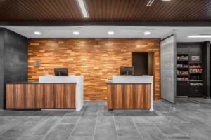 a lobby with two reception desks and a brick wall at Courtyard by Marriott Jonesboro in Jonesboro