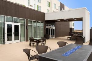 a patio with tables and chairs on a building at Courtyard by Marriott Jonesboro in Jonesboro