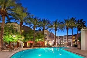 uma piscina com palmeiras e edifícios em Residence Inn Scottsdale North em Scottsdale