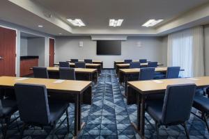 a conference room with tables and chairs and a screen at Courtyard by Marriott New Haven Wallingford in Wallingford