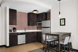 una cocina con armarios de madera y una mesa con sillas. en Residence Inn by Marriott Philadelphia Langhorne en Langhorne