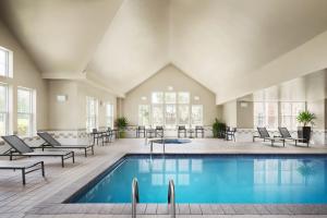 una piscina en un edificio con sillas y mesas en Residence Inn by Marriott Philadelphia Langhorne, en Langhorne