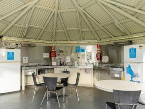 - une cuisine avec deux tables et des chaises dans une pièce dans l'établissement NRMA Bairnsdale Riverside Holiday Park, à Bairnsdale