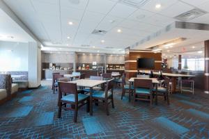 une salle à manger avec des tables, des chaises et une télévision dans l'établissement Fairfield Inn & Suites by Marriott Wichita Falls Northwest, à Wichita Falls