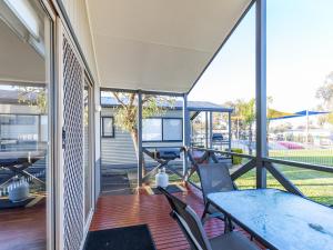 un patio aperto con tavolo e sedie su una terrazza di NRMA Yarrawonga Mulwala Holiday Park a Mulwala