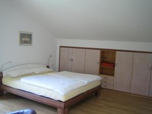 a bedroom with a bed and wooden cabinets at Ferienwohnung Mautweg in Bad Reichenhall