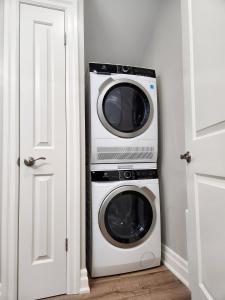 a microwave and a washer and dryer in a room at The Cozy Cove Modern King-Bedroom Full Apartment in St. Catharines