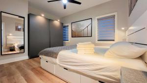 a bedroom with a large bed with white sheets at The Cozy Cove Modern King-Bedroom Full Apartment in St. Catharines