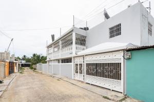 a white building with a gate on a street at SDQ airport & Samana bus near Bamboo in Santo Domingo