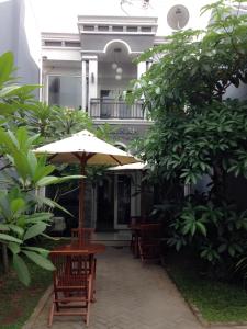 a table and chairs with an umbrella in front of a building at Safa Homestay in Yogyakarta