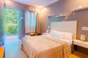 a bedroom with a large bed and a window at The Ridge Coron in Coron