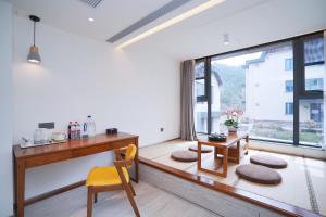 a home office with a desk and a window at Jiushui Heyuan Art Design Hotel in Qingdao