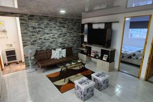 een woonkamer met een bank en een flatscreen-tv bij Terranova, apto en el Salvador in Medellín