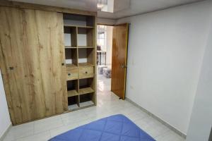 een kamer met een kast en een blauw tapijt bij Terranova, apto en el Salvador in Medellín