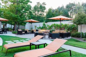 een patio met stoelen, tafels en parasols bij Courtyard by Marriott Livermore in Livermore