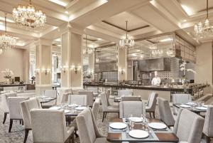 a restaurant with tables and chairs and a chef in the kitchen at Rizal Park Hotel in Manila