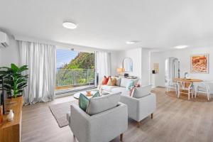 ein Wohnzimmer mit einem Sofa, Stühlen und einem Tisch in der Unterkunft Amazing beach view and perfect location Kirra in Gold Coast