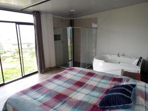 1 dormitorio con cama, bañera y lavamanos en habitación en Villa Tina, en Santa Rosa de Cabal