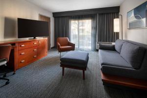 a living room with a couch and a tv at Courtyard by Marriott Bakersfield in Bakersfield