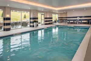 a large swimming pool with blue water in a building at Fairfield Inn & Suites by Marriott Altoona in Altoona