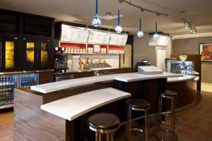 a bar in a restaurant with two stools at Courtyard by Marriott Columbus Tipton Lakes in Columbus