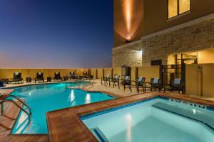 ein großer Pool in einem Hotelzimmer mit Stühlen in der Unterkunft Courtyard By Marriott Houston Kingwood in Kingwood