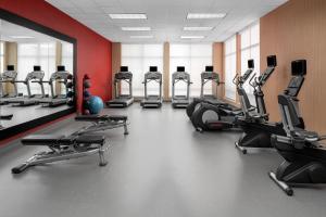 un gimnasio con una fila de cintas de correr y elípticas en Courtyard By Marriott Houston Kingwood, en Kingwood