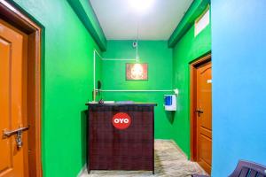 - une salle de bains avec des murs verts et un comptoir dans la chambre dans l'établissement OYO Flagship Hotel Elite Inn, à Bhubaneswar