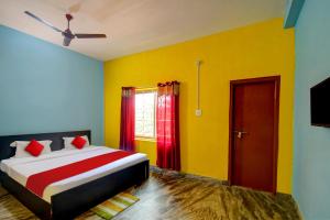 - une chambre avec un lit aux murs colorés et une fenêtre dans l'établissement OYO Flagship Hotel Elite Inn, à Bhubaneswar