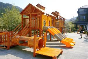 a playground with a slide in a park at Jiushui Heyuan Art Design Hotel in Qingdao