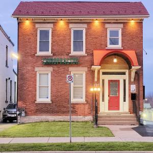 a brick house with a no parking sign in front of it at The Cozy Cove Modern King-Bedroom Full Apartment in St. Catharines